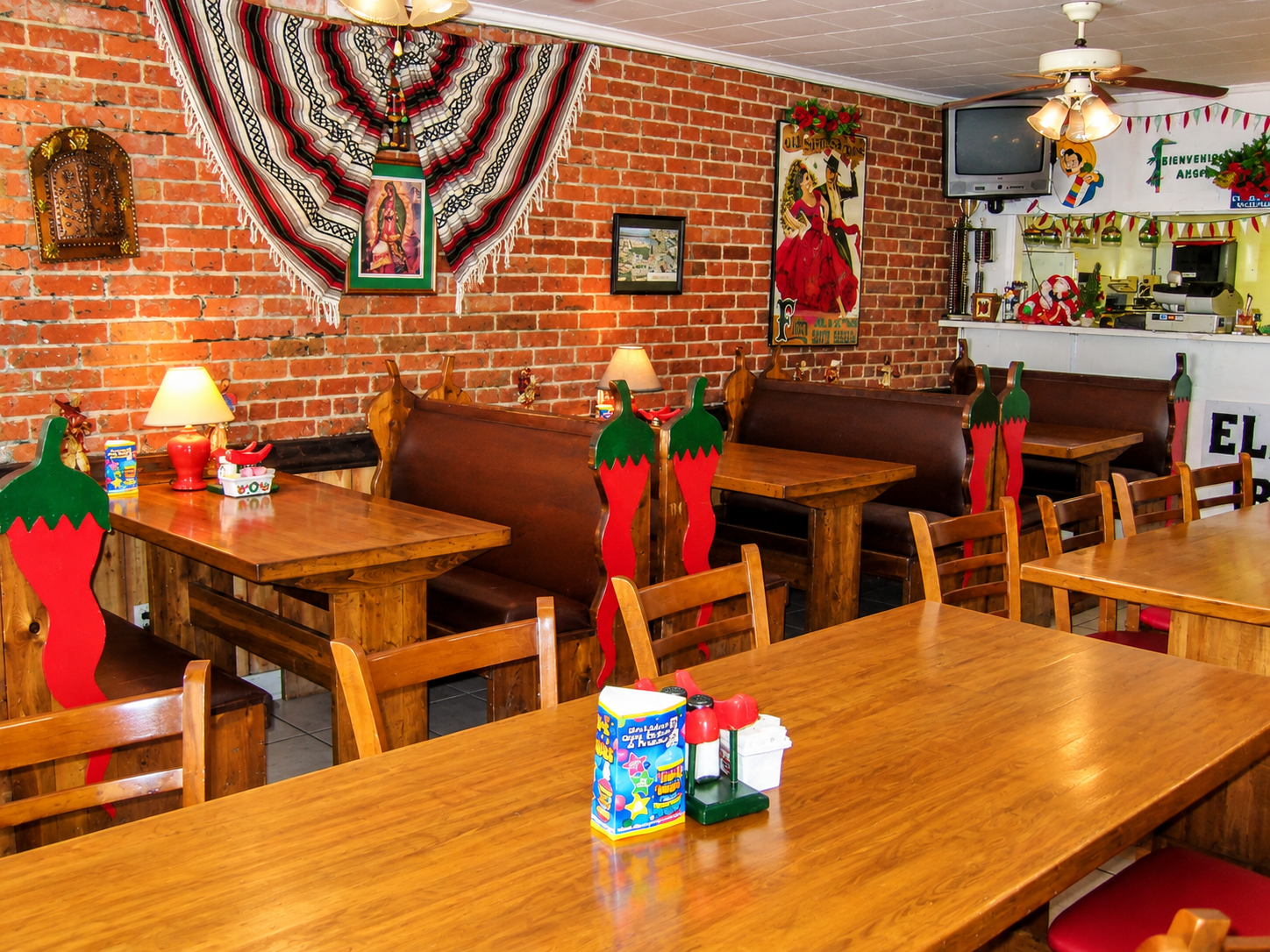 Restaurant dining room with brick walls and chili pepper booths
